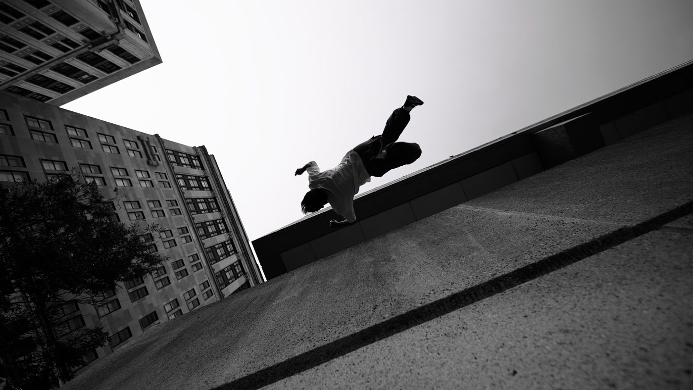 Sage Moore mid-flip against a building